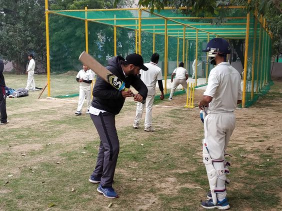 Coach teaching player about bat swing